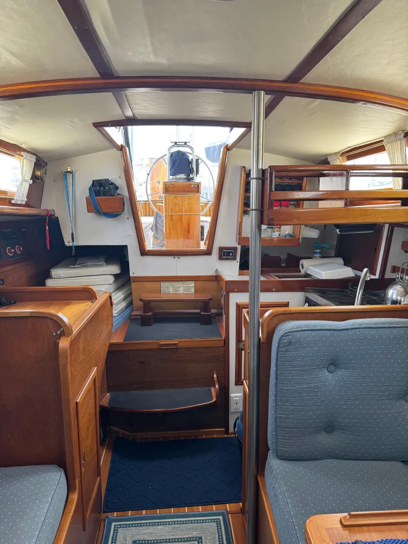 Slide: The Image of Interior of a 1984 Ohlson 38 sailboat, featuring wooden cabinetry and cozy seating. - 30