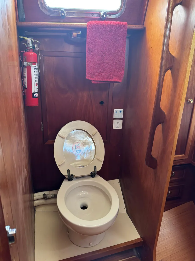 Slide: The Image of Ohlson 38 yacht bathroom with toilet, fire extinguisher, and red towel, 1984 model. - 33