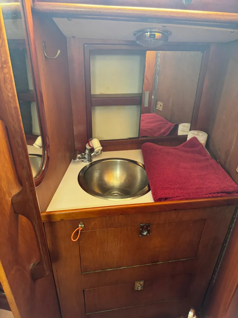 Slide: The Image of Wooden bathroom vanity with sink and mirror in 1984 Ohlson 38 sailboat. - 34