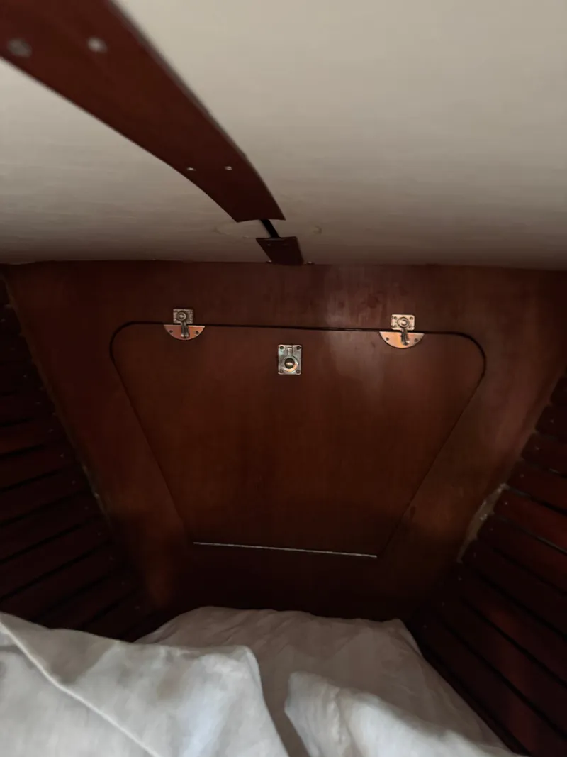 Slide: The Image of Interior cabin of 1984 Ohlson 38 sailboat with wooden paneling and storage compartment. - 38