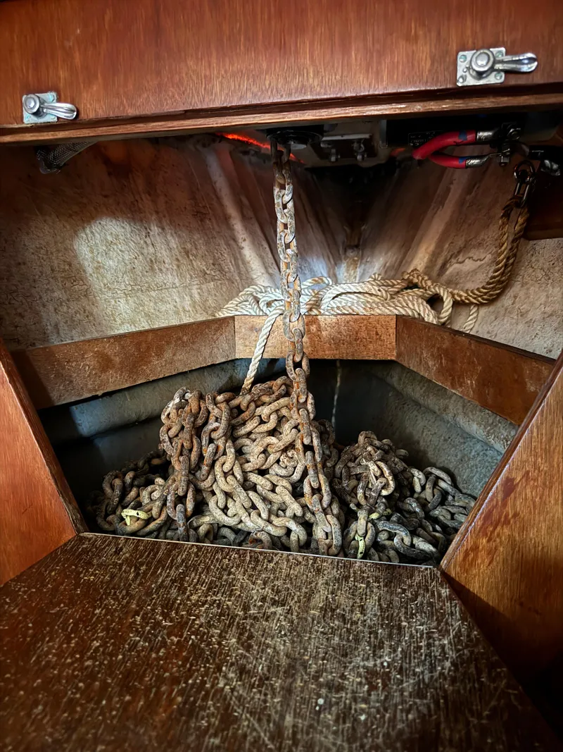 Slide: The Image of Anchor chain storage in 1984 Ohlson 38 sailboat, featuring wooden interior. - 40