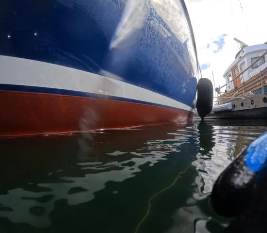 Slide: The Image of 1984 Ohlson 38 sailboat hull in water, docked at marina. - 8