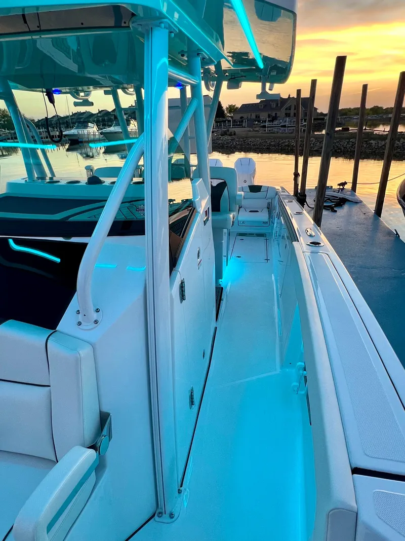 Slide: The Image of 2024 Wellcraft 352 Fisherman boat docked at sunset with blue interior lighting. - 13