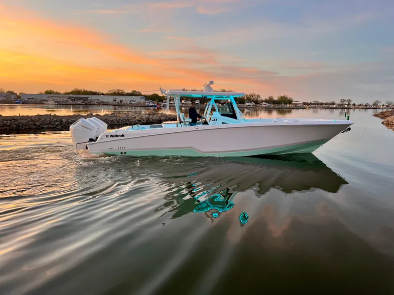 Slide: The Image of 2024 Wellcraft 352 Fisherman boat cruising on calm water at sunset. - 5