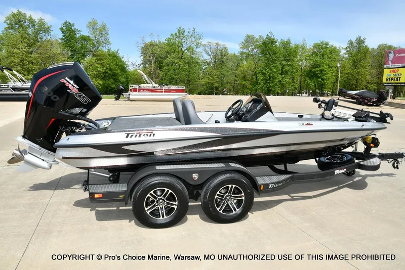 Slide: The Image of 2024 Triton 18 TRX boat with 200 Pro-XS engine on trailer, parked outdoors. - 17
