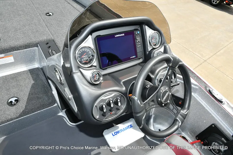 Slide: The Image of 2024 Triton 18 TRX boat dashboard with steering wheel and Lowrance display. - 40