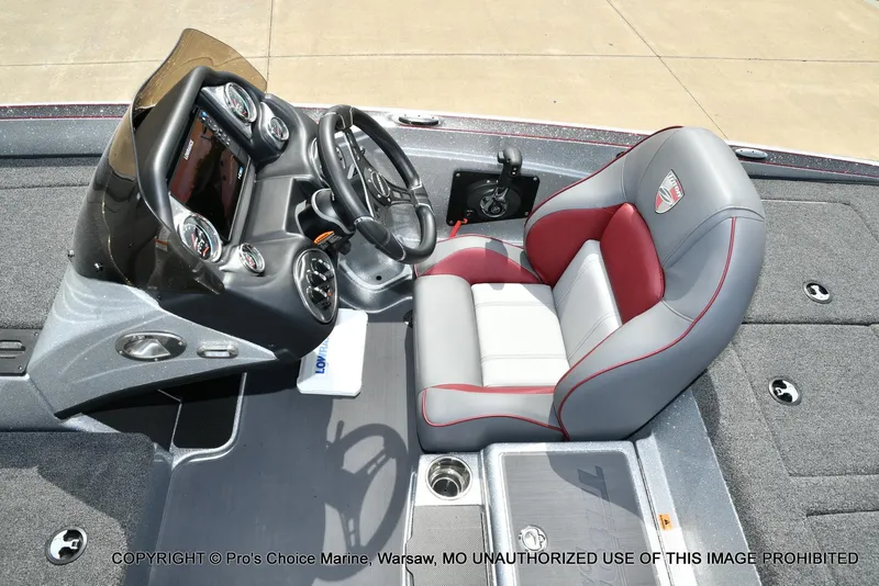 Slide: The Image of 2024 Triton 18 TRX boat cockpit with steering wheel and cushioned seat. - 41