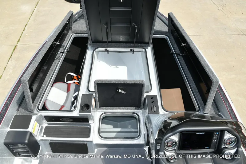 Slide: The Image of 2024 Triton 18 TRX boat interior with open storage compartments and control panel. - 9