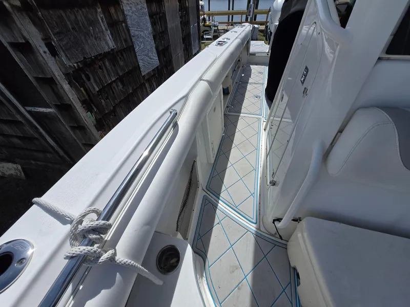 Slide: The Image of 2013 Boston Whaler 280 Outrage boat deck with white seating and railing. - 11