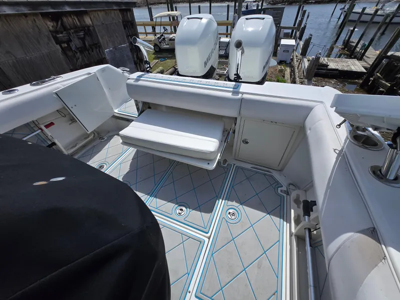 Slide: The Image of 2013 Boston Whaler 280 Outrage boat deck with seating and storage, docked by the water. - 15