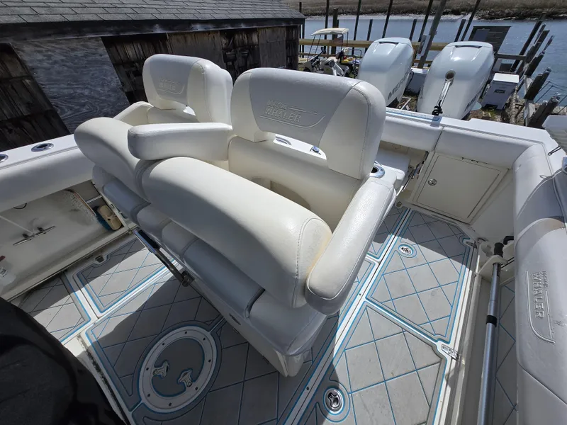 Slide: The Image of 2013 Boston Whaler 280 Outrage boat with white seating and patterned deck. - 24