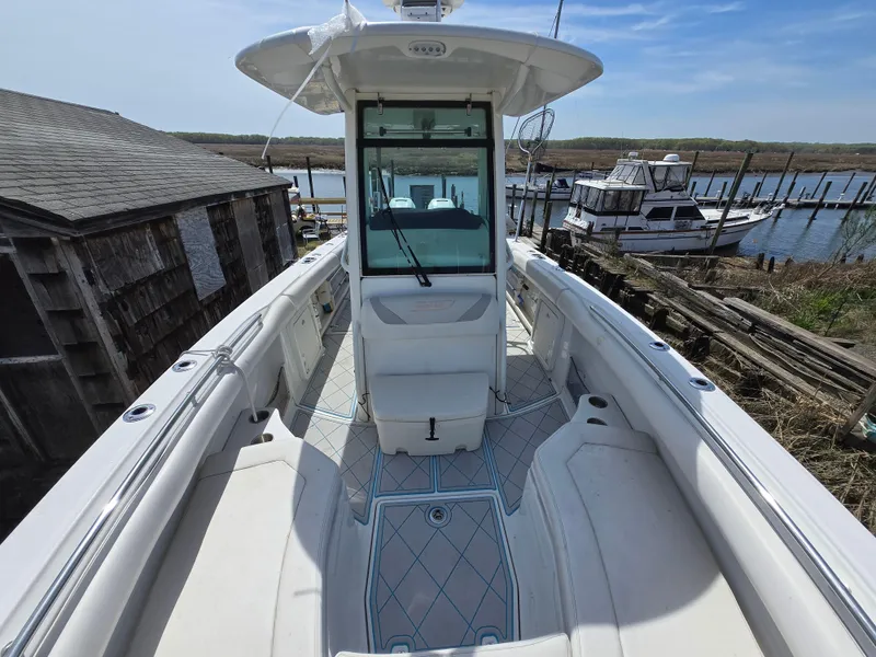 Slide: The Image of 2013 Boston Whaler 280 Outrage boat docked, showcasing spacious deck and sleek design. - 8