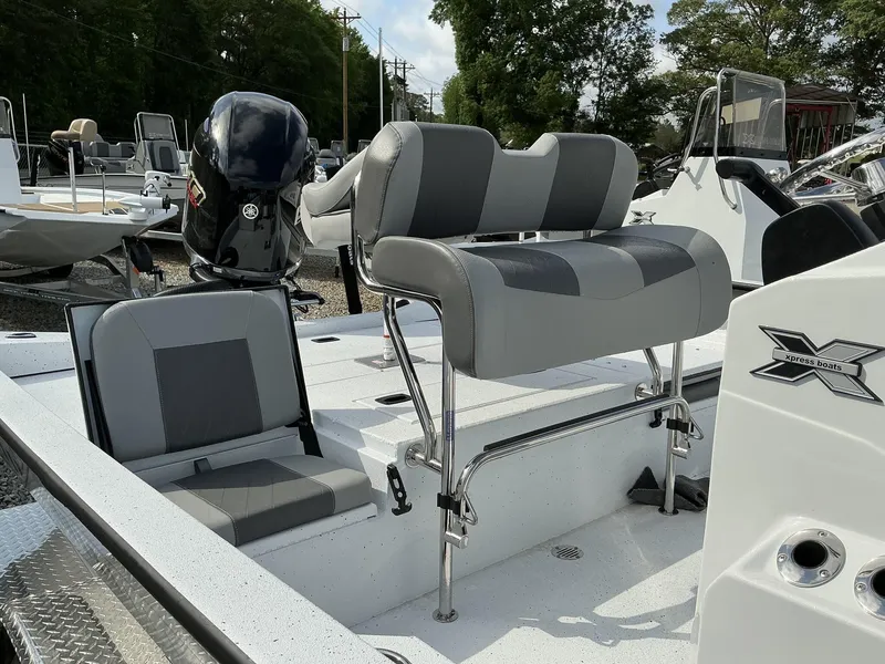 Slide: The Image of 2025 Xpress Hyper-Lift Series H22B boat interior with seating and motor, in a showroom setting. - 10