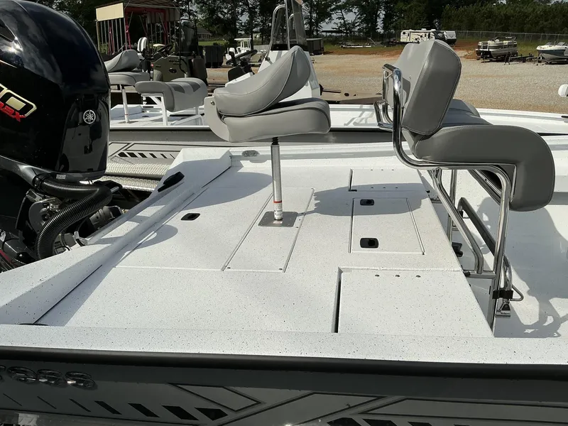 Slide: The Image of 2025 Xpress Hyper-Lift Series H22B boat with seating and motor, parked outdoors. - 12