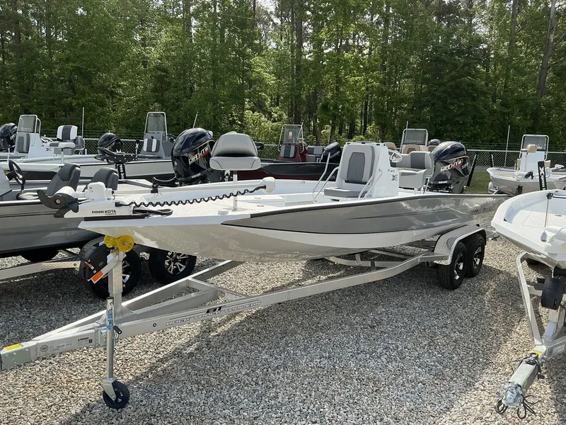 Slide: The Image of 2025 Xpress Hyper-Lift Series H22B boat on trailer, surrounded by trees and other boats. - 5