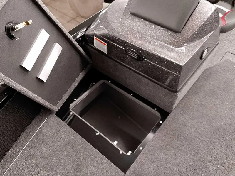 Slide: The Image of 2025 Ranger VS1782SC Angler boat storage compartment with open lid and carpeted interior. - 9