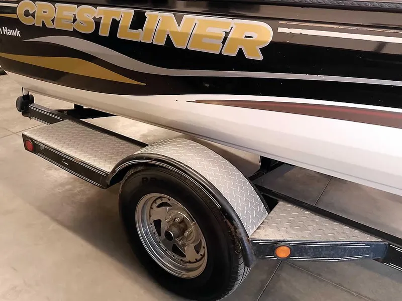 Slide: The Image of 2006 Crestliner 1850 Fish Hawk DC boat on trailer, featuring bold logo and sleek design. - 12