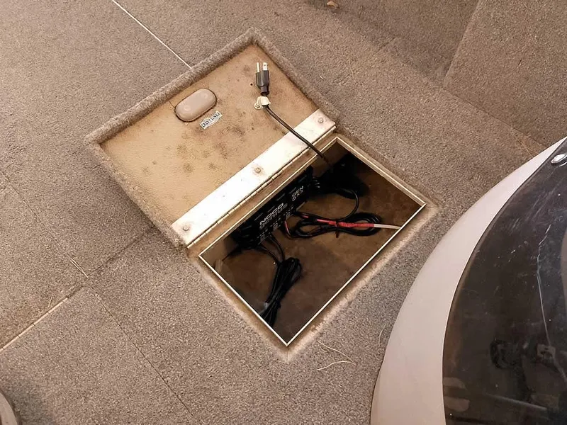 Slide: The Image of 2006 Crestliner 1850 Fish Hawk DC boat storage compartment with wiring and carpeted interior. - 16