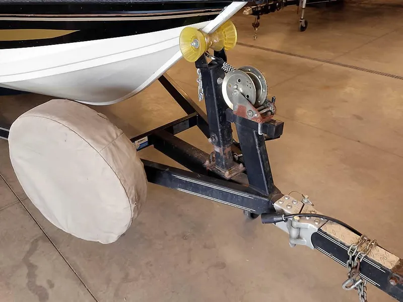 Slide: The Image of 2006 Crestliner 1850 Fish Hawk DC boat trailer with covered wheel in a garage. - 5