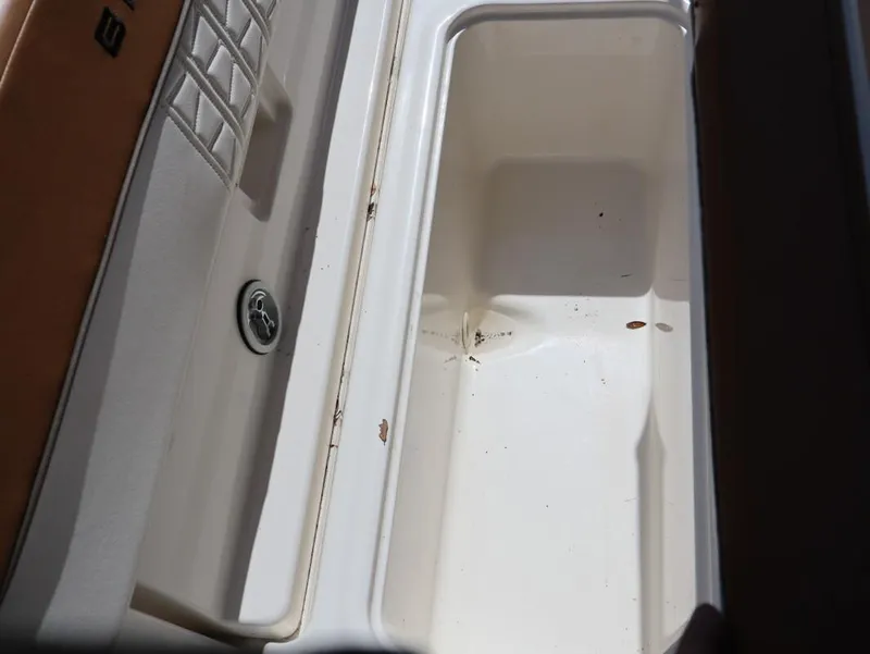Slide: The Image of 2022 Bayliner VR4 Bowrider Outboard storage compartment, white interior, partially open. - 18