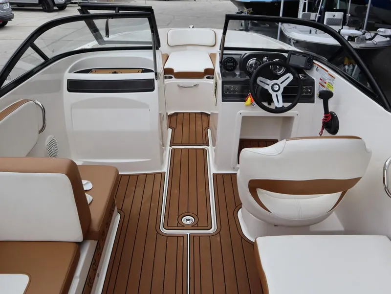 Slide: The Image of 2022 Bayliner VR4 Bowrider Outboard interior with brown and white seating, modern dashboard. - 8
