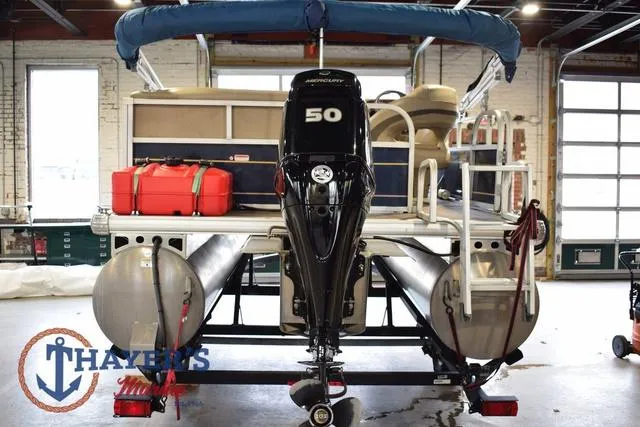 Slide: The Image of 2020 Sun Tracker Bass Buggy® 16 XL pontoon boat with Mercury 50 engine in a garage. - 4