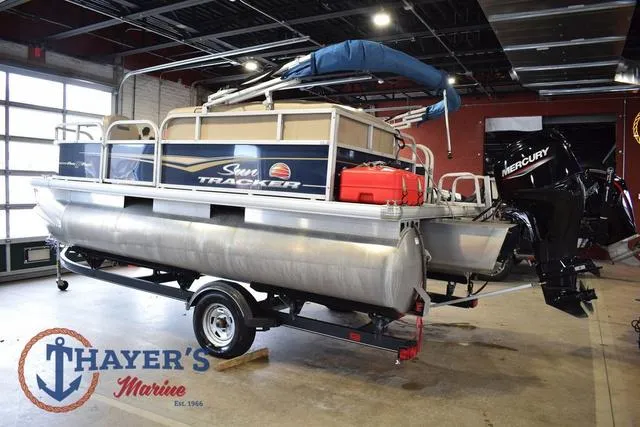 Slide: The Image of 2020 Sun Tracker Bass Buggy® 16 XL pontoon boat in showroom, featuring Mercury outboard motor. - 5