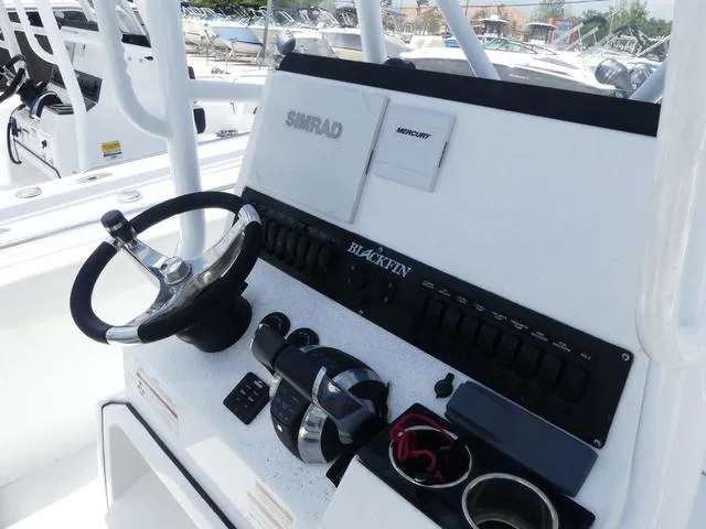 Slide: The Image of 2021 Blackfin 252CC boat console with steering wheel and control panel. - 11