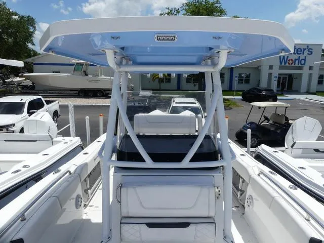 Slide: The Image of 2021 Blackfin 252CC boat with T-top, parked at a marina under a clear sky. - 17