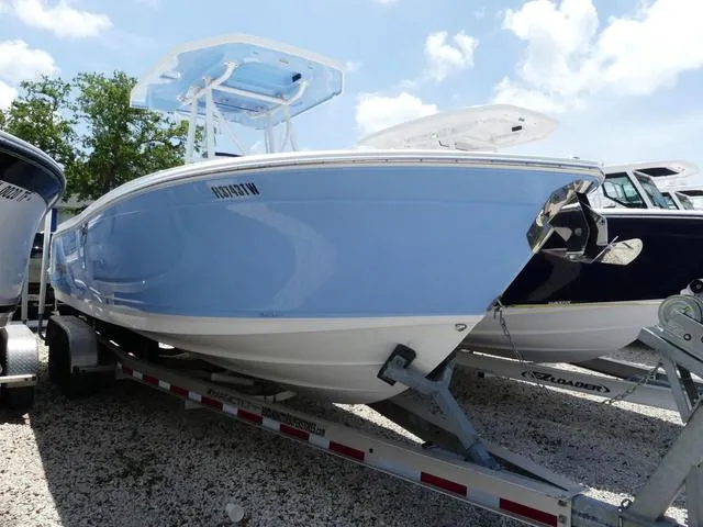 Slide: The Image of 2021 Blackfin 252CC boat on trailer, light blue hull, sunny day. - 2