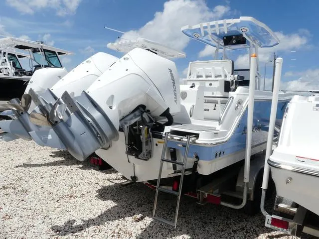 Slide: The Image of 2021 Blackfin 252CC boat with twin outboard engines on a gravel lot. - 5