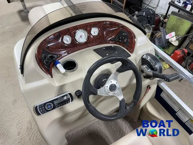 Slide: The Image of 2014 Sun Tracker Fishin Barge pontoon boat dashboard with steering wheel and controls. - 17