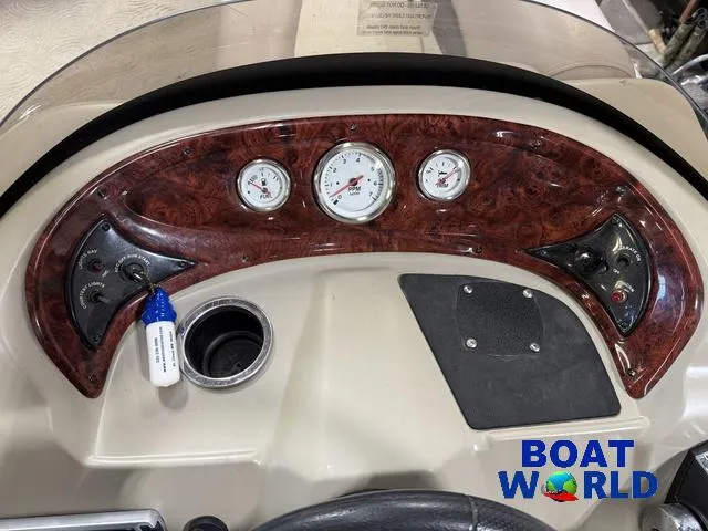 Slide: The Image of 2014 Sun Tracker Fishin Barge dashboard with gauges and controls, featuring wood paneling. - 19