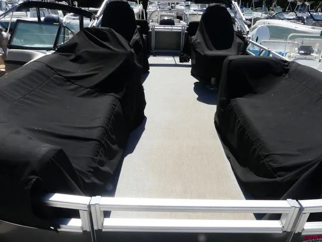 Slide: The Image of 2022 Avalon Catalina Platinum Quad Lounger boat with covered seating, docked at marina. - 5