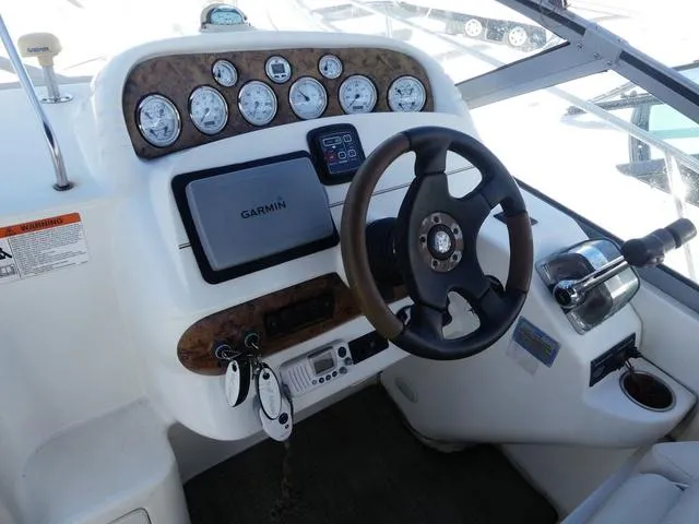 Slide: The Image of 2005 Larson 330 CABRIO boat dashboard with steering wheel, gauges, and Garmin navigation system. - 12
