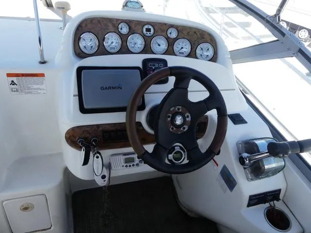 Slide: The Image of 2005 Larson 330 CABRIO boat dashboard with Garmin GPS and steering wheel. - 13