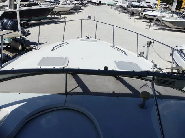 Slide: The Image of 2005 Larson 330 CABRIO boat deck view in a marina with multiple boats. - 15