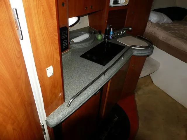 Slide: The Image of 2005 Larson 330 CABRIO boat interior with kitchenette and bed. - 18