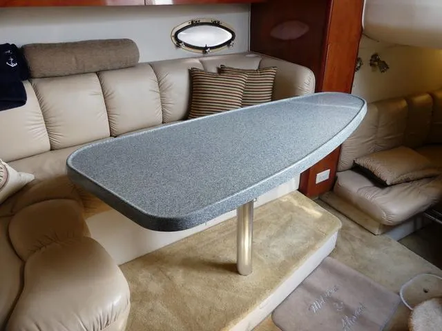 Slide: The Image of Interior of 2005 Larson 330 CABRIO with modern table and plush seating. - 21