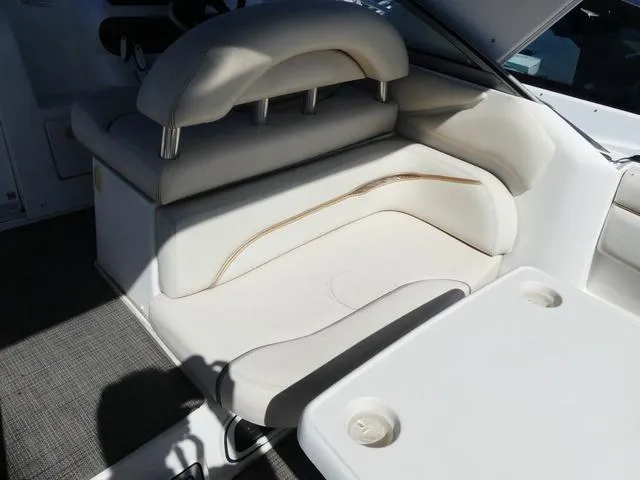 Slide: The Image of 2005 Larson 330 CABRIO boat interior with white seating and table. - 9