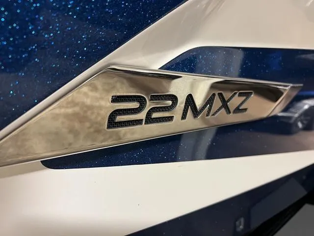 Slide: The Image of 2014 Malibu Wakesetter 22 MXZ logo on blue and white boat exterior. - 4