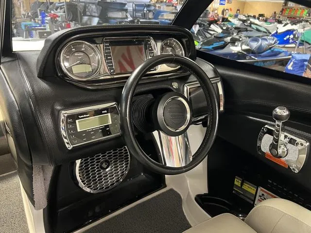 Slide: The Image of Interior dashboard of a 2014 Malibu Wakesetter 22 MXZ boat with steering wheel and controls. - 8