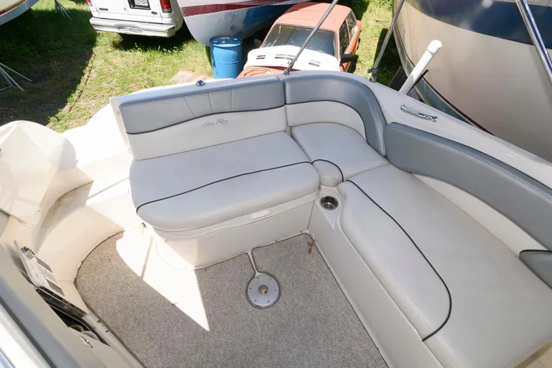 Slide: The Image of 2009 Sea Ray 240 Sundeck interior with gray seating and carpeted floor. - 11