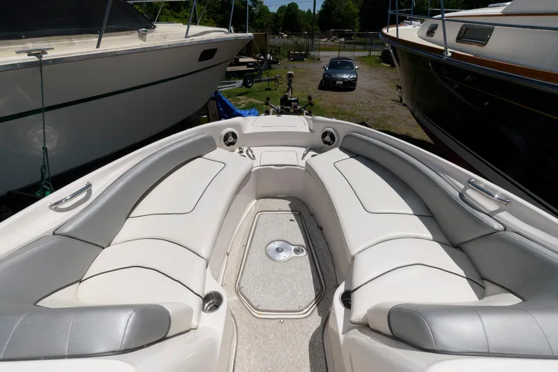 Slide: The Image of 2009 Sea Ray 240 Sundeck boat interior with white seating in a marina setting. - 4