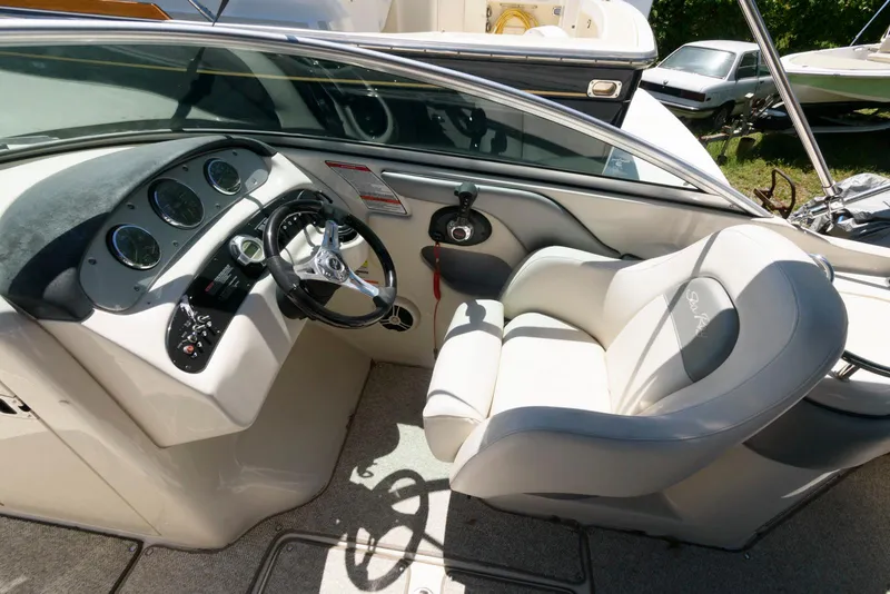 Slide: The Image of 2009 Sea Ray 240 Sundeck boat interior with steering wheel and comfortable seating. - 7