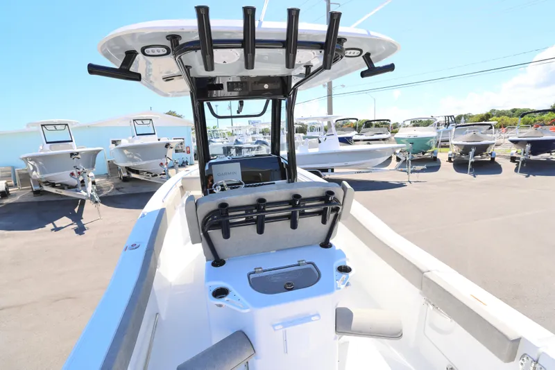 Slide: The Image of 2025 Sea Hunt Ultra 239 SE boat interior with rod holders and console, docked outdoors. - 4
