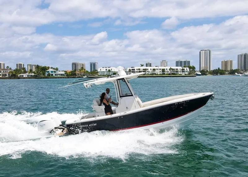 The Image of 2024 Regulator 23 boat cruising on water with city skyline in background. - 0