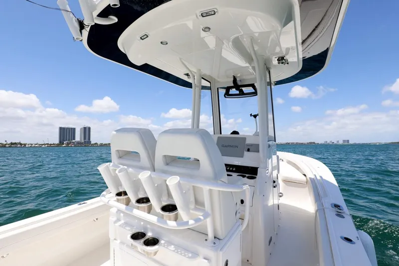 Slide: The Image of 2024 Regulator 23 boat on water, featuring center console and rod holders. - 18