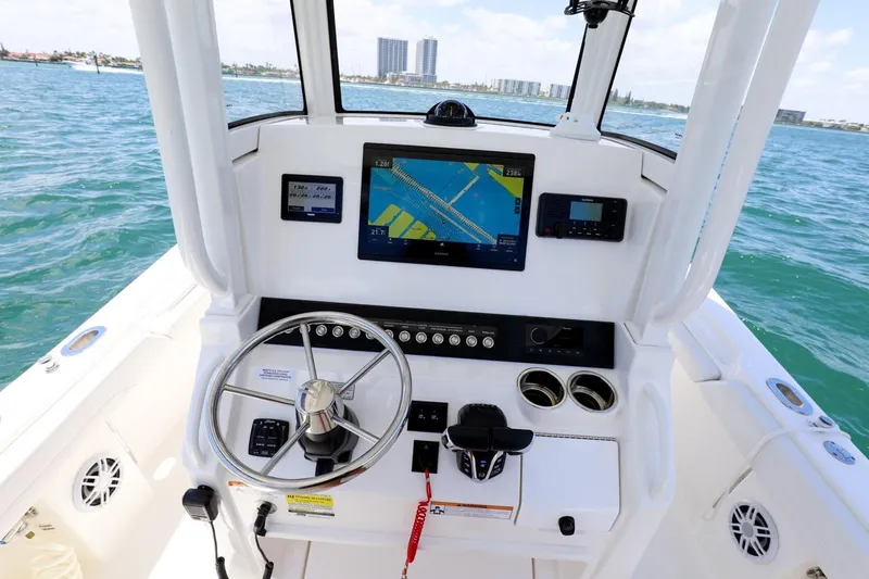 Slide: The Image of 2024 Regulator 23 boat dashboard with navigation system, steering wheel, and ocean view. - 24