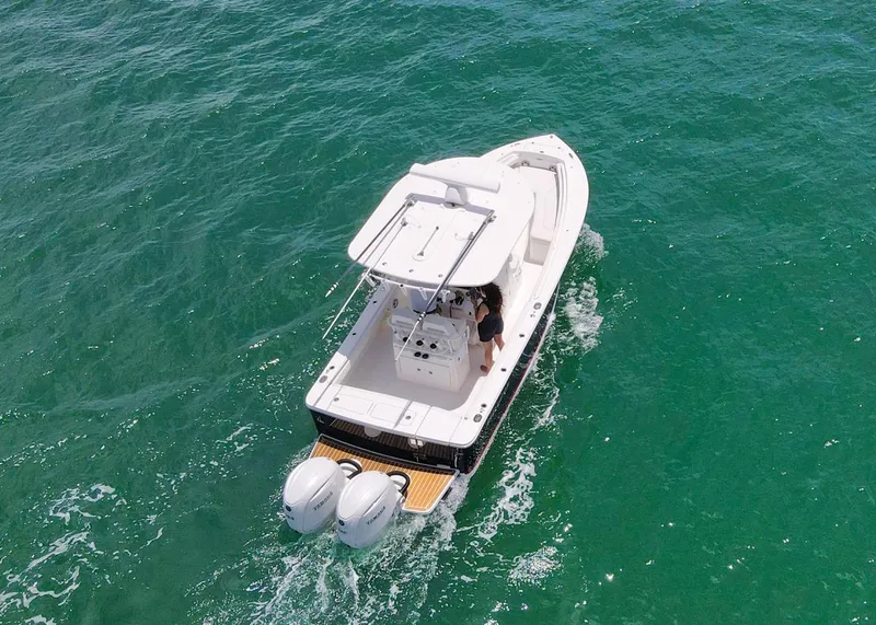 Slide: The Image of 2024 Regulator 23 boat cruising on clear turquoise water, aerial view. - 31